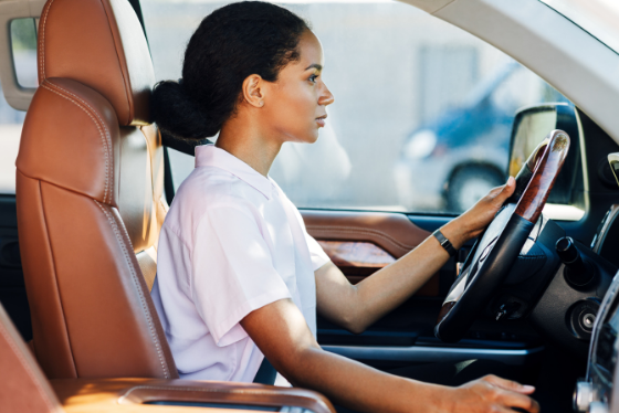 Woman driving in luxury car.